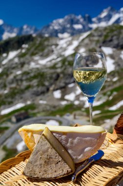 Peynir koleksiyonu, Fransız Alpleri 'ndeki Savoy bölgesinden Reblochon ve Tomme de Savoie peyniri, açık havada hafif inek sütü, Fransız Alpler dağlarının karlı tepelerinde manzara