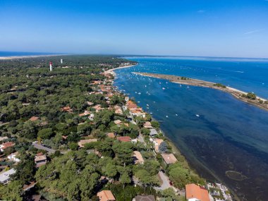 Arcachon Körfezi 'nde Le Phare du Cap Ferret ve Duna du Pilat yakınlarındaki balıkçı tekneleri ve istiridye çiftlikleri, Fransa' nın Bordeaux 'nun güneybatısındaki Cap Ferret yarımadası, güneşli bir günde Fransa' nın Atlantik kıyıları.