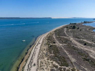 Güneşli bir günde Fransa 'nın Atlantik kıyıları Bordeaux' nun güneybatısında Le Phare du Cap Ferret, Cap Ferret yarımadası yakınlarındaki balıkçı tekneleri ve istiridye çiftlikleriyle Arcachon Körfezi 'ndeki hava manzarası.