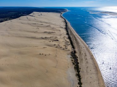 Güneşli bir günde Fransa 'nın Atlantik kıyı şeridi boyunca Bordeaux' nun güneybatısında Arcachon Körfezi bölgesindeki La Teste-de-Buch 'da yer alan Avrupa' nın en uzun kum tepeciğinin havadan görünüşü