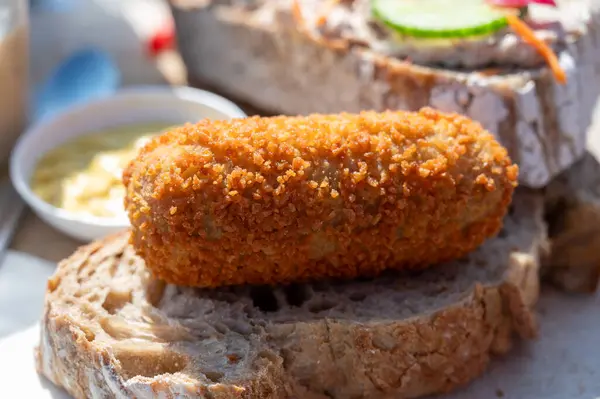 Dutch fast food, deep fried croquettes filled with ground beef meat served on bread, close up