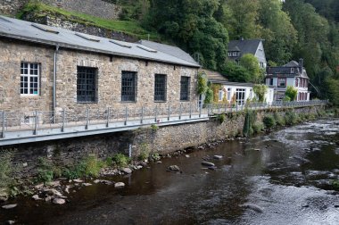 Nehrin kıvrımlarındaki eski renkli Alman şehri Monschau 'nun evleri ve caddeleri görünüyor ve tepelerin arasında saklanıyor, Eifel Ulusal Parkı, Almanya yazın.