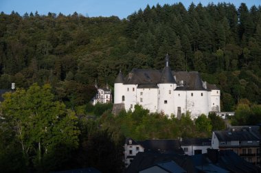 Clervaux 'nun manzarası, kuzey Lüksemburg ve yeşil ormanlarda şehir statüsü ile birleşiyor. Clervaux Kantonu' nun başkenti, günbatımında beyaz kale.