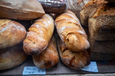 Doğal mayayla yapılan ekşi hamurlu biyolojik ekmek ve Fransa 'da gıda pazarında odun sobasında pişirildi.