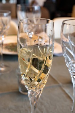 Yılbaşı yemeği, şampanya ve kristal bardaklarda şarap ile servis edilir. Noel ağacı, çelenkler, yemek odası arka planı.