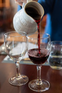 Hasat sona erdiğinde bardaklara kırmızı beaujolais şarabı dökmek ve Fransa 'nın Limouges kentindeki beyaz seramik sürahisinden Kasım ayının üçüncü perşembesinde ilk satışını yapmak.