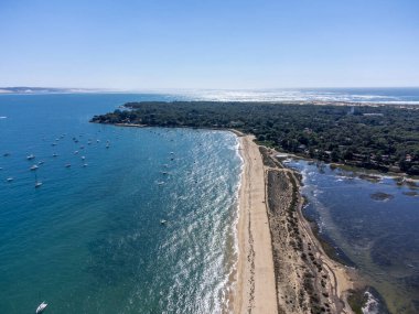 Güneşli bir günde Fransa 'nın Atlantik kıyıları Bordeaux' nun güneybatısında Le Phare du Cap Ferret, Cap Ferret yarımadası yakınlarındaki balıkçı tekneleri ve istiridye çiftlikleriyle Arcachon Körfezi 'ndeki hava manzarası.