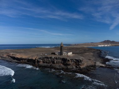 Punta de Jandia ve Fuerteventura adasının güney ucunda deniz feneri, sadece çakıl yolu ile ulaşılabilir, güneşli kış günü.