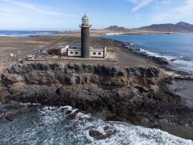 Punta de Jandia ve Fuerteventura adasının güney ucunda deniz feneri, sadece çakıl yolu ile ulaşılabilir, güneşli kış günü.