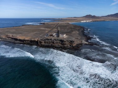 Punta de Jandia ve Fuerteventura adasının güney ucunda deniz feneri, sadece çakıl yolu ile ulaşılabilir, güneşli kış günü.