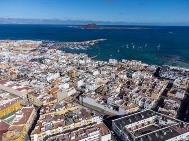 Hava manzaralı Corralejo kasabası, liman, siyah kayalar, mavi su, Lobos ve Lanzarote adaları, Fuerteventura, Kanarya adaları, İspanya, kış tatili