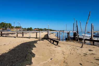 Güneşli bir günde Fransa 'nın Atlantik kıyı şeridi Bordeaux' nun güneybatısında Le Phare du Cap Ferret, Cap Ferret yarımadası yakınlarındaki birçok balıkçı teknesi ve istiridye çiftliğiyle Arcachon Körfezi 'ne bakın.
