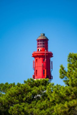 Kızıl Fener Le Phare du Cap Ferret, Arcachon Körfezi yakınlarındaki balıkçı tekneleri ve istiridye çiftlikleri, Fransa, Bordeaux 'nun güneybatısı, Fransa' nın Atlantik kıyı şeridi, mavi gökyüzü.
