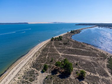 Güneşli bir günde Fransa 'nın Atlantik kıyıları Bordeaux' nun güneybatısında Le Phare du Cap Ferret, Cap Ferret yarımadası yakınlarındaki balıkçı tekneleri ve istiridye çiftlikleriyle Arcachon Körfezi 'ndeki hava manzarası.