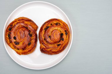 Fırında kahvaltı, taze pişmiş iki kahve, üzümlü tatlı çörek, sabah yemeği.