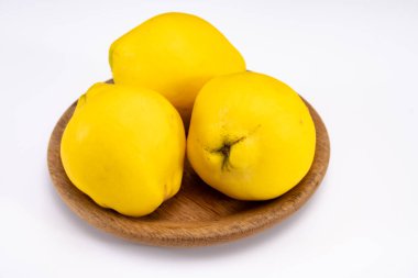 Olgun sarı ayva elmaları grubu beyaz arkaplanı izole ediyor.