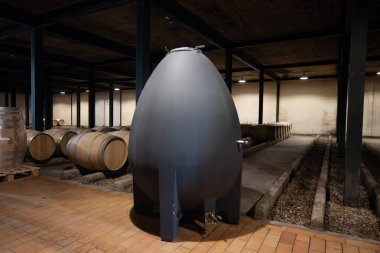 WIne celler with french concrete egg shape wine tank for aging of red wines, Haut-Medoc vineyards in Bordeaux, left bank Gironde Estuary, Pauillac, France clipart
