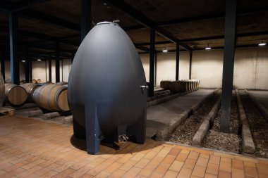 WIne celler with french concrete egg shape wine tank for aging of red wines, Haut-Medoc vineyards in Bordeaux, left bank Gironde Estuary, Pauillac, France clipart