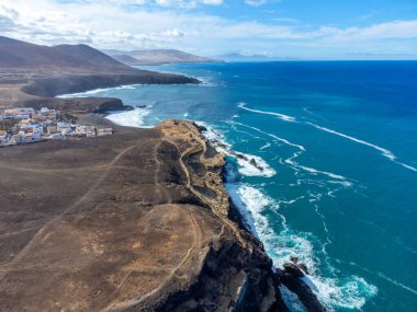 West coast of Fuerteventura island. View on blue water and black volcanic caves of Ajuy village, Canary islands, Spain. clipart