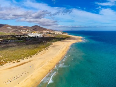 Beyaz kumlu sahil ve Morro Jable tatil köyündeki mavi okyanus suyu Fuerteventura, Kanarya Adaları, İspanya 'nın güneyinde, kışın