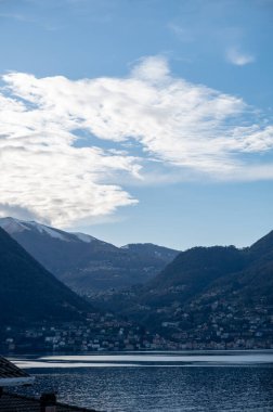Kuzey İtalya 'da Como Gölü kıyıları boyunca araba sürmek, baharın güneşli günleri, dağların manzarası, su ve köyler.
