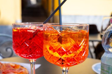 Aperol ve Campari Spritz portakal suyu. Likör, Prosecco köpüklü şarap, buz küpleri ve bir parça portakal, Bellagio, İtalya.