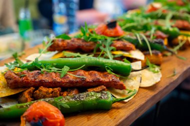 İstanbul 'daki lokantada mangal kömürü ızgarasından ahşap tabak, ızgara et, tavuk kanadı, kuzu eti, şiş kebap, biber.