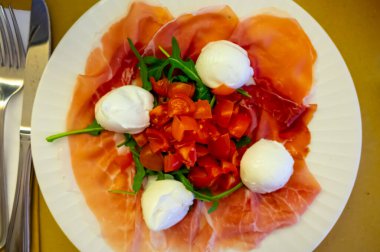 Emilia-Romagna bölgesi mutfağı, İtalyan jambonlu Caprese salatası, prosciutto di Parma, mozzarella ve domates, Parma, İtalya 'da öğle yemeği.