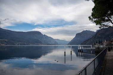 Kuzey İtalya 'da Como Gölü kıyıları boyunca araba sürmek, baharın güneşli günleri, dağların manzarası, su ve köyler.