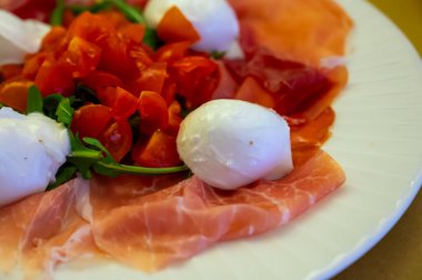 Emilia-Romagna bölgesi mutfağı, İtalyan jambonlu Caprese salatası, prosciutto di Parma, mozzarella ve domates, Parma, İtalya 'da öğle yemeği.