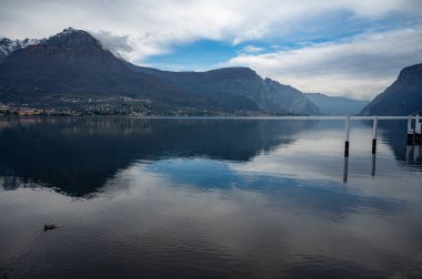 Kuzey İtalya 'da Como Gölü kıyıları boyunca araba sürmek, baharın güneşli günleri, dağların manzarası, su ve köyler.
