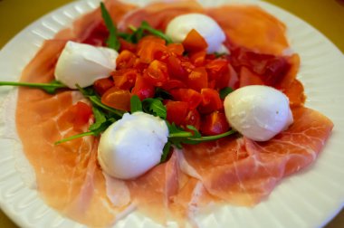 Emilia-Romagna bölgesi mutfağı, İtalyan jambonlu Caprese salatası, prosciutto di Parma, mozzarella ve domates, Parma, İtalya 'da öğle yemeği.
