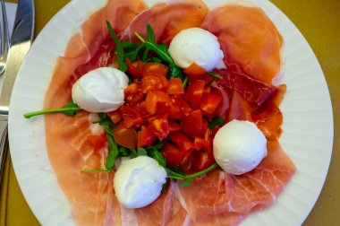 Emilia-Romagna bölgesi mutfağı, İtalyan jambonlu Caprese salatası, prosciutto di Parma, mozzarella ve domates, Parma, İtalya 'da öğle yemeği.