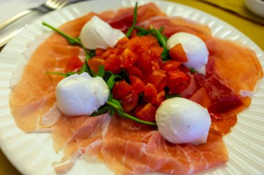 Emilia-Romagna bölgesi mutfağı, İtalyan jambonlu Caprese salatası, prosciutto di Parma, mozzarella ve domates, Parma, İtalya 'da öğle yemeği.
