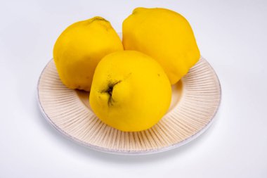 Olgun sarı ayva elmaları grubu beyaz arkaplanı izole ediyor.