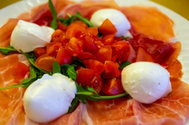 Emilia-Romagna bölgesi mutfağı, İtalyan jambonlu Caprese salatası, prosciutto di Parma, mozzarella ve domates, Parma, İtalya 'da öğle yemeği.