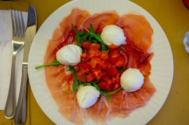 Emilia-Romagna bölgesi mutfağı, İtalyan jambonlu Caprese salatası, prosciutto di Parma, mozzarella ve domates, Parma, İtalya 'da öğle yemeği.