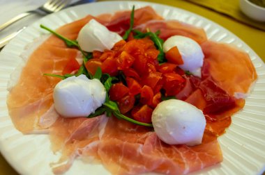 Emilia-Romagna bölgesi mutfağı, İtalyan jambonlu Caprese salatası, prosciutto di Parma, mozzarella ve domates, Parma, İtalya 'da öğle yemeği.