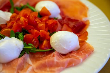 Emilia-Romagna bölgesi mutfağı, İtalyan jambonlu Caprese salatası, prosciutto di Parma, mozzarella ve domates, Parma, İtalya 'da öğle yemeği.