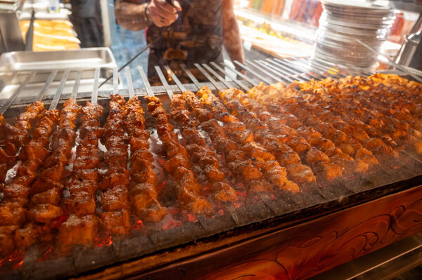 Turkish mixed grill meat, chicken wings, lamb, beef shashlik, kebab cooking on charcoal grill in restaurant in Istanbul