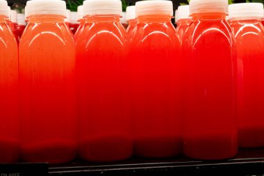 Taze böğürtlenli taze kırmızı ezilmiş kırmızı çilek suyu şişeleri.