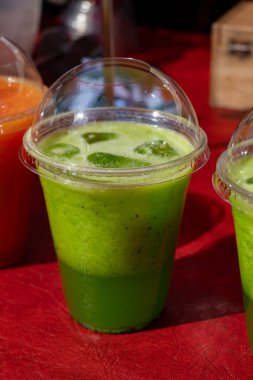 Taze meyveli yeşil kivi suyu. Taze meyve, böğürtlen ve plastik bardakta buz.