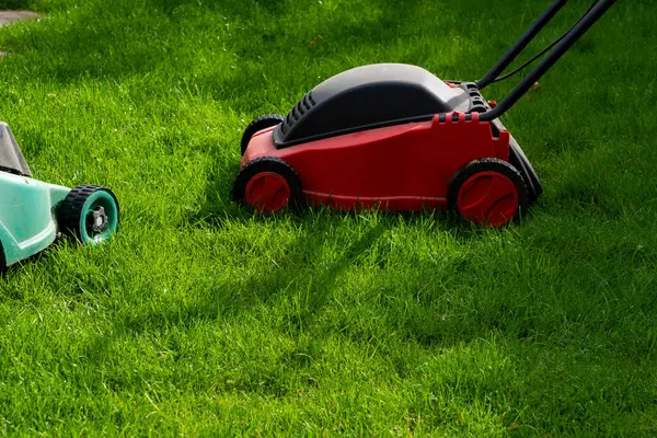 Seasonal maintenance works in garden, lawn movers in action, green grass cutting, lawn care, English lawn, garden keeping background