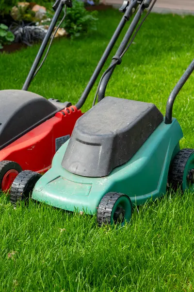 Seasonal maintenance works in garden, lawn movers in action, green grass cutting, lawn care, English lawn, garden keeping background
