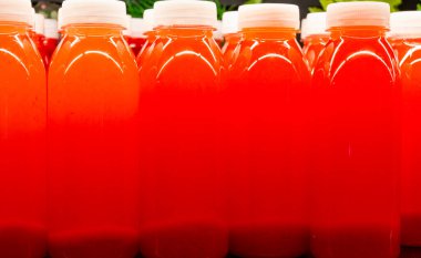 Taze böğürtlenli taze kırmızı ezilmiş kırmızı çilek suyu şişeleri.