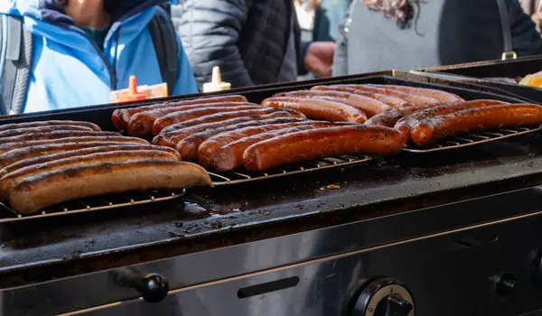 German street food on Portobello road Saturday food market, London, Uk, many BBQ grilled sausages ready to eat in outdoor cafe