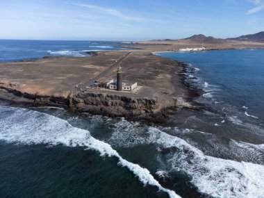 Punta de Jandia ve Fuerteventura adasının güney ucunda deniz feneri, sadece çakıl yolu ile ulaşılabilir, güneşli kış günü.