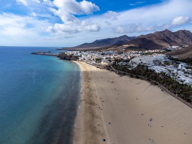 Beyaz kumlu sahil ve Morro Jable tatil köyündeki mavi okyanus suyu Fuerteventura, Kanarya Adaları, İspanya 'nın güneyinde, kışın