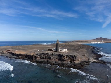 Punta de Jandia ve Fuerteventura adasının güney ucunda deniz feneri, sadece çakıl yolu ile ulaşılabilir, güneşli kış günü.