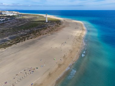 Beyaz kumlu sahil ve Morro Jable tatil köyündeki mavi okyanus suyu Fuerteventura, Kanarya Adaları, İspanya 'nın güneyinde, kışın
